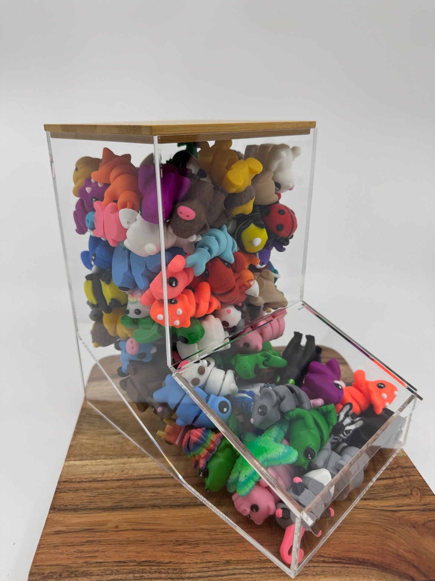 Countertop display bin filled with colorful 3D printed collectible minis